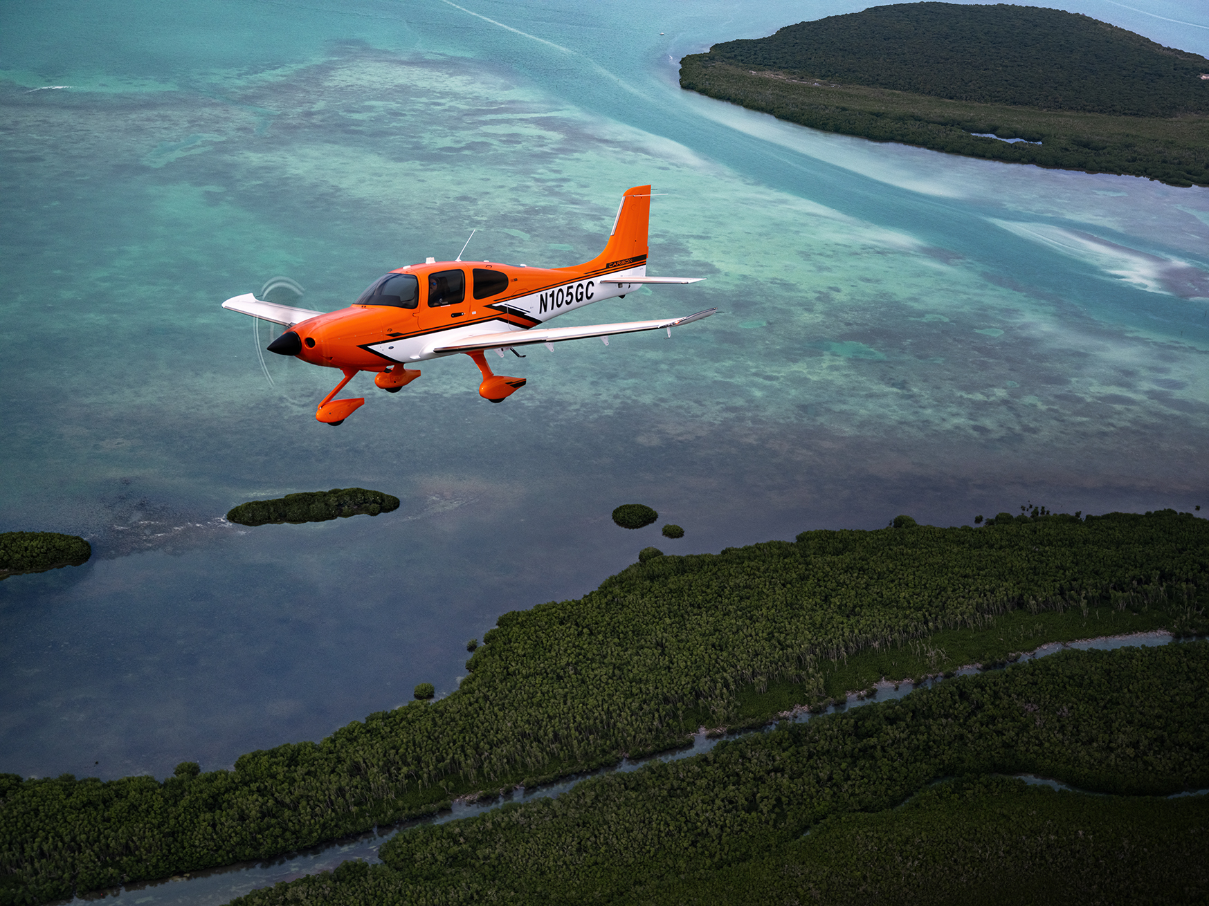 Cirrus SR22 i orange lackering över karibiska vatten