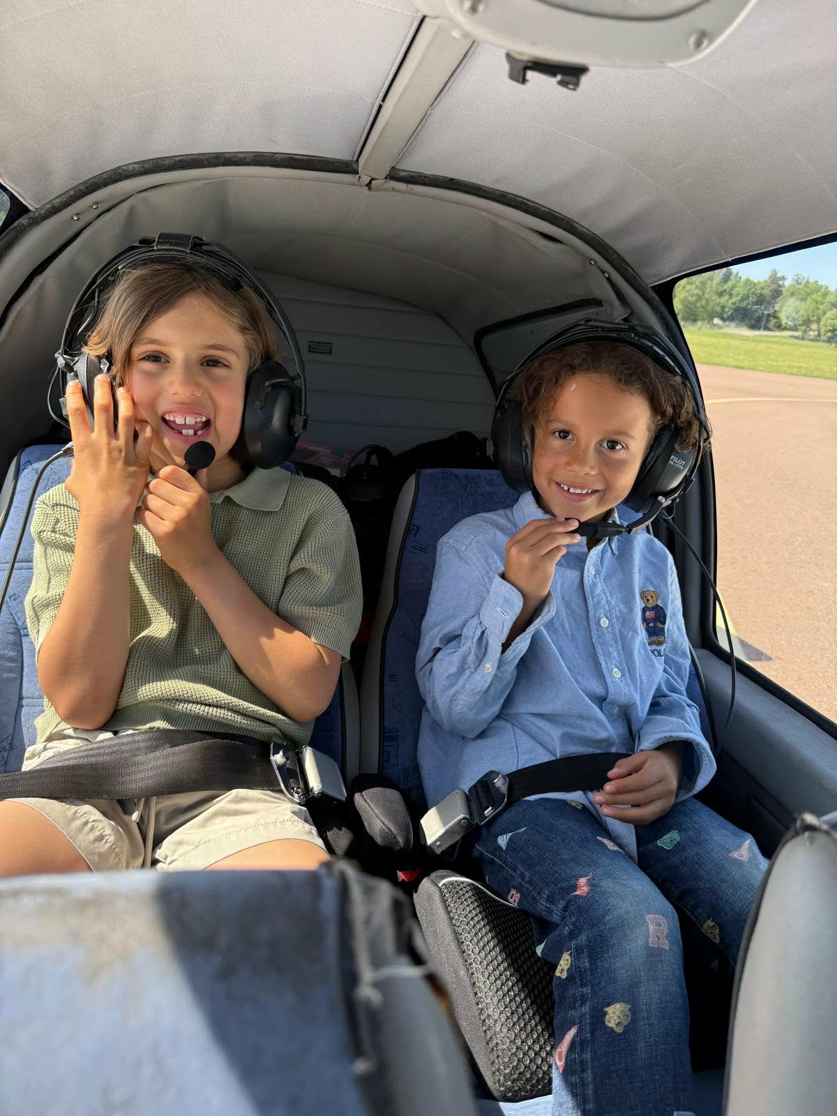 Två barn med headset i cockpit på ett skolflygplan